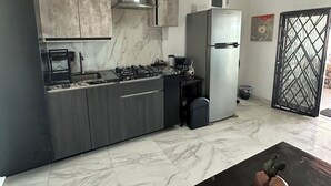 Een moderne keuken met een gasfornuis, roestvrijstalen apparatuur en marmeren vloeren.