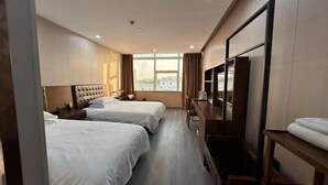 A hotel room with two beds, a TV, a desk, and a window with a city view. - Sushi Hotel (Shanghai Hongqiao International Exhibition Center Branch) (Shanghai)