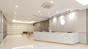 A hotel reception area with a marble counter, a reception desk, and a patterned wall. - Sushi Hotel (Shanghai Hongqiao International Exhibition Center Branch) (Shanghai)