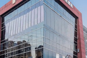 A modern building with a glass facade and a red accent wall. - Sushi Hotel (Shanghai Hongqiao International Exhibition Center Branch) (Shanghai)