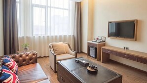 A hotel room with a sofa, a chair, a coffee table, a TV, and a minibar. - Sushi Hotel (Shanghai Hongqiao International Exhibition Center Branch) (Shanghai)