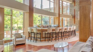 A spacious, modern bar area with high ceilings and large windows, offering a view of the outdoors. - The Lodge at Turning Stone Resort Casino (Verona)