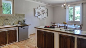 A kitchen with a dishwasher, a sink, and a dining area with a table and chairs.
