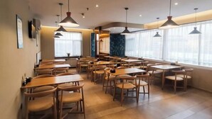 A spacious dining area with multiple tables and chairs, large windows with sheer curtains, and pendant lighting. - Pebble Hotel (Taiyuan Hengshan Road Taigang East Gate) (Taiyuan)