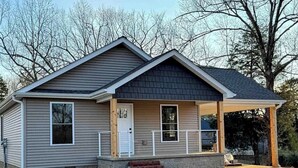 A single-story house with a gabled roof, a front porch, and a covered entryway. - Kentucky Lake Retreat / 1 Mile to Jonathan Creek / Boat Parking (Benton)
