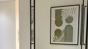 Ein gerahmtes Kunstwerk mit abstrakten Blattmotiven an einer Wand.