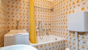 Een badkamer met douche, toilet en wastafel.
