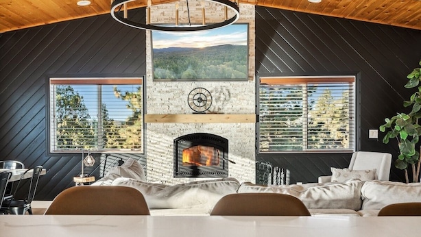 Un intérieur moderne avec une cheminée, de grandes fenêtres et un coin repas.