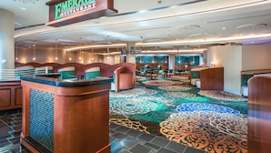 A restaurant with a sign reading 'Emerald Restaurant,' a patterned carpet, and a reception desk. - The Tower at Turning Stone Resort Casino (Verona)