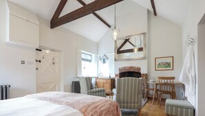 Une chambre à coucher avec un lit, une cheminée, un bureau et une chaise.