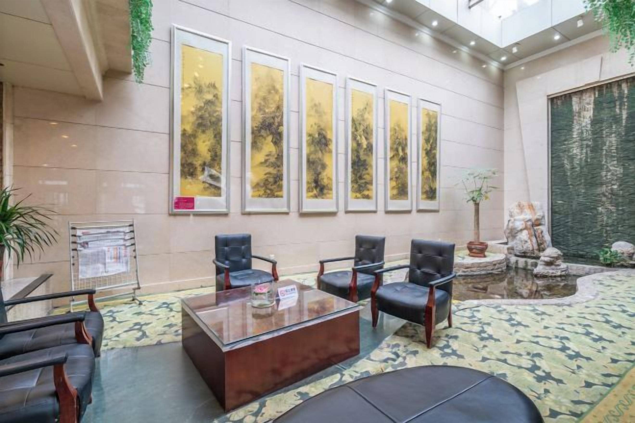 A lobby with a reception desk, seating area, and a decorative fountain.
