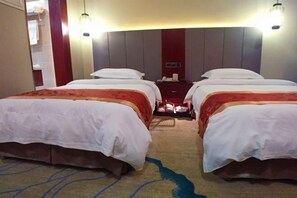 A hotel room with two beds, a small desk, and a nightstand. - Zhoukou Hotel (Zhoukou Wanshunda Department Store) (Zhoukou)