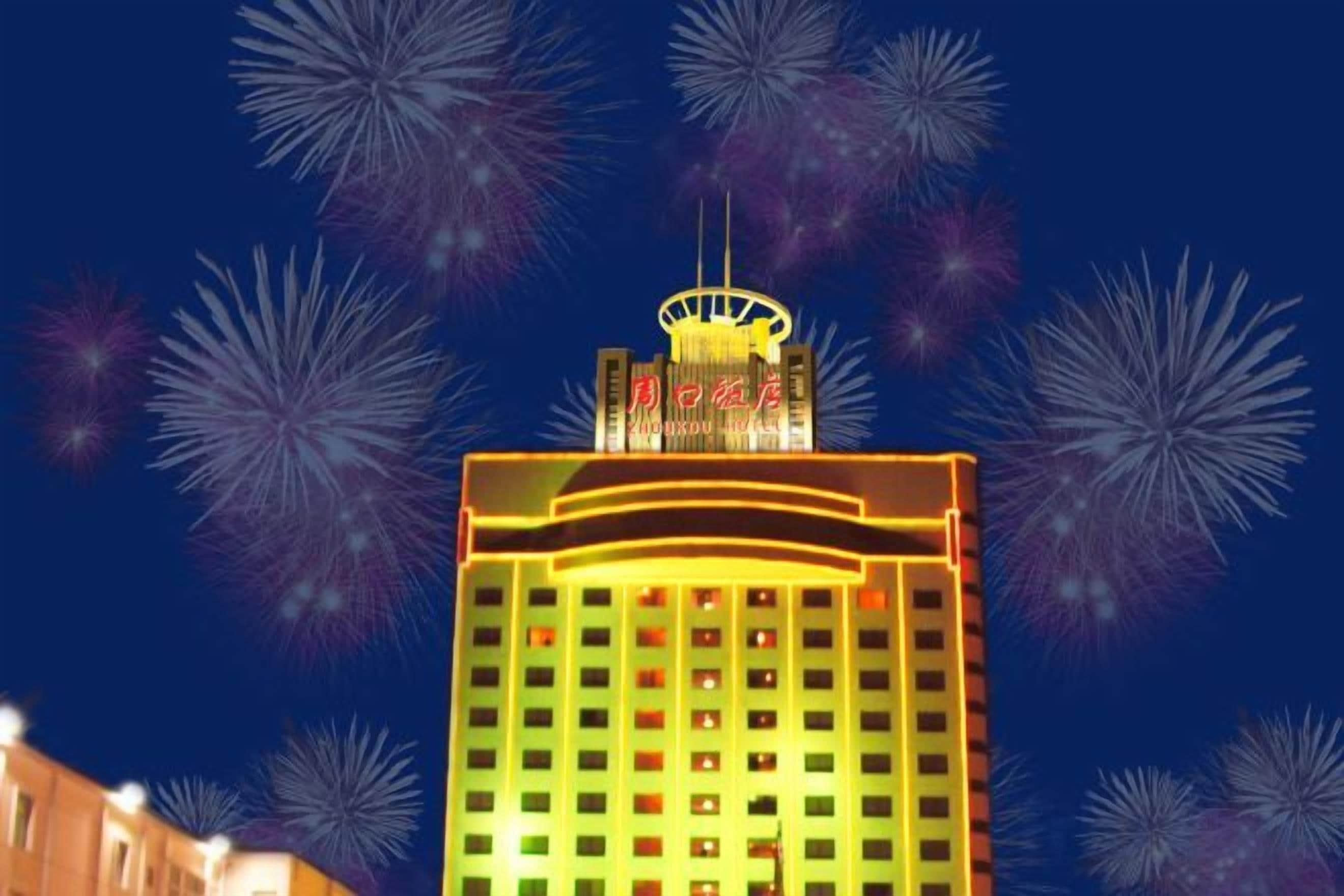 A hotel with a prominent, illuminated sign at the top and a facade with evenly spaced windows.
