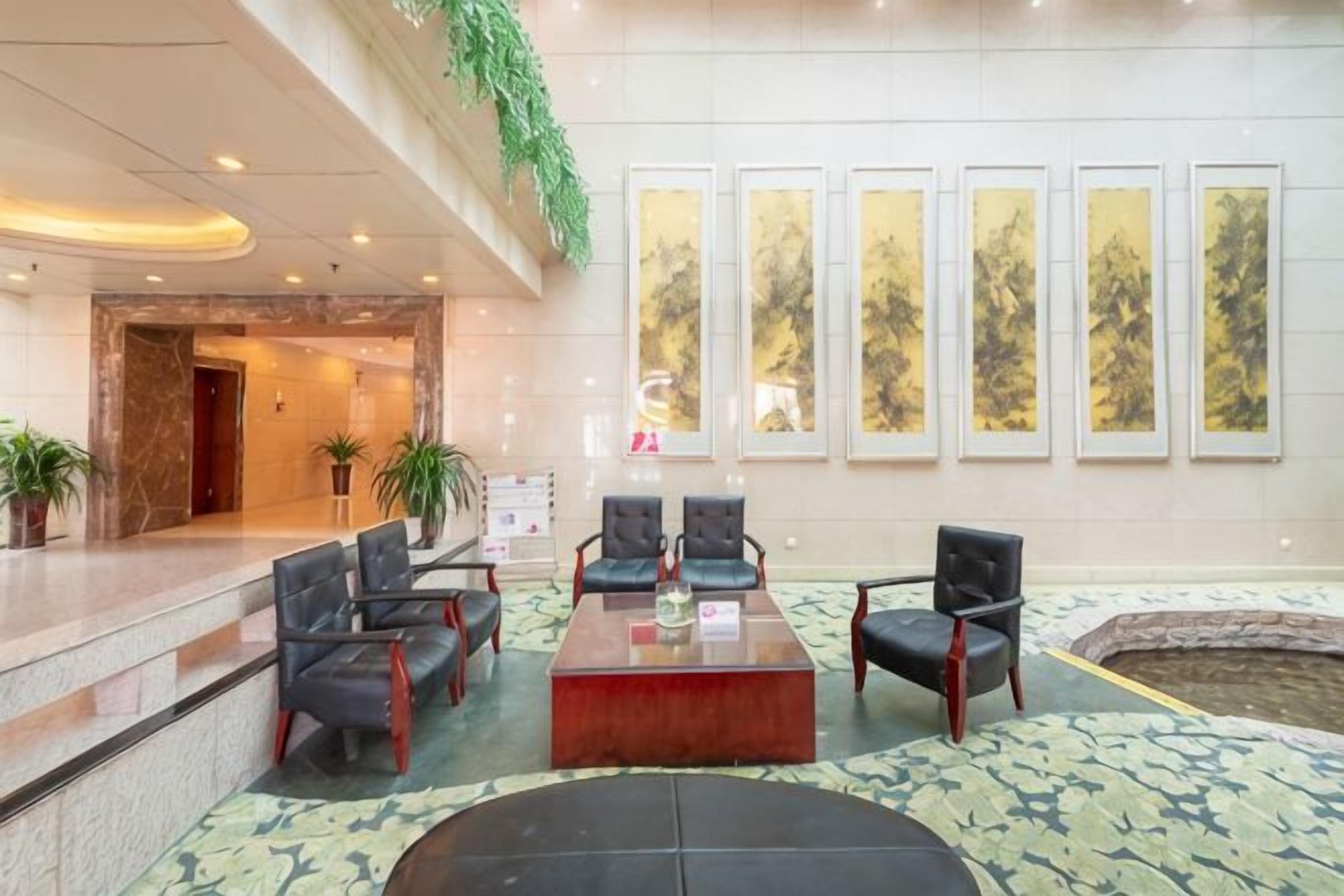 A lobby with a reception desk, seating area, and artwork on the walls.