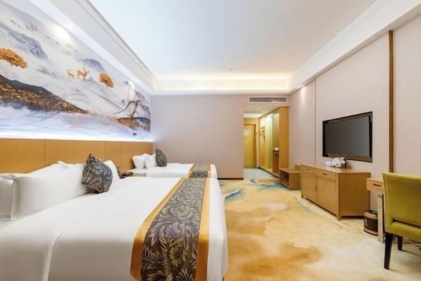A hotel room with two beds, a large mural, a television, and a carpeted floor. - Antai Hotel (Maoming)