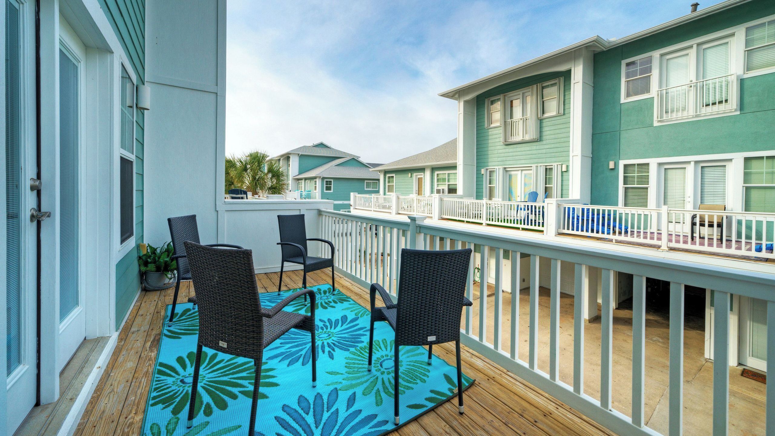 A balcony with outdoor furniture and a view of neighboring houses.
