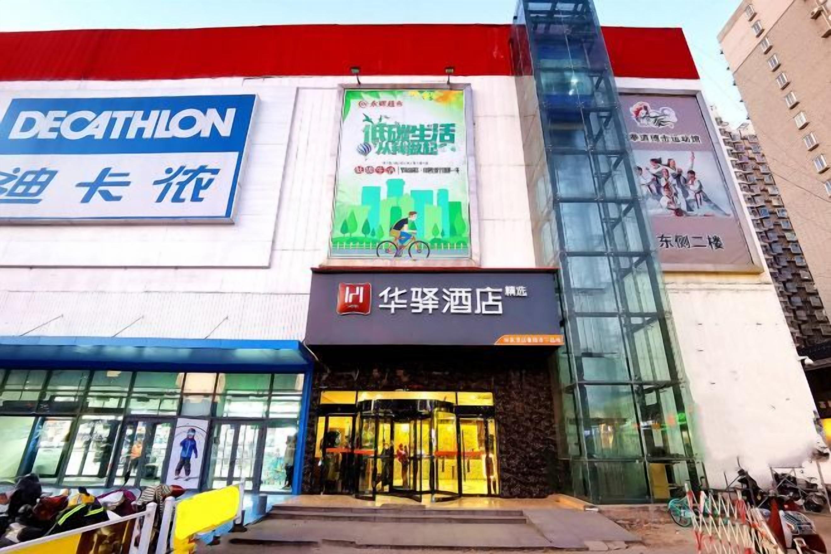 A hotel with a modern facade, a prominent entrance with glass doors, and signage in multiple languages.