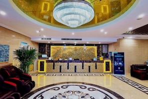 A hotel lobby with a reception desk, a large chandelier, and a decorative floor pattern. - Huayi Hotel(Shijiazhuang Huai'an East Road) (Shijiazhuang)