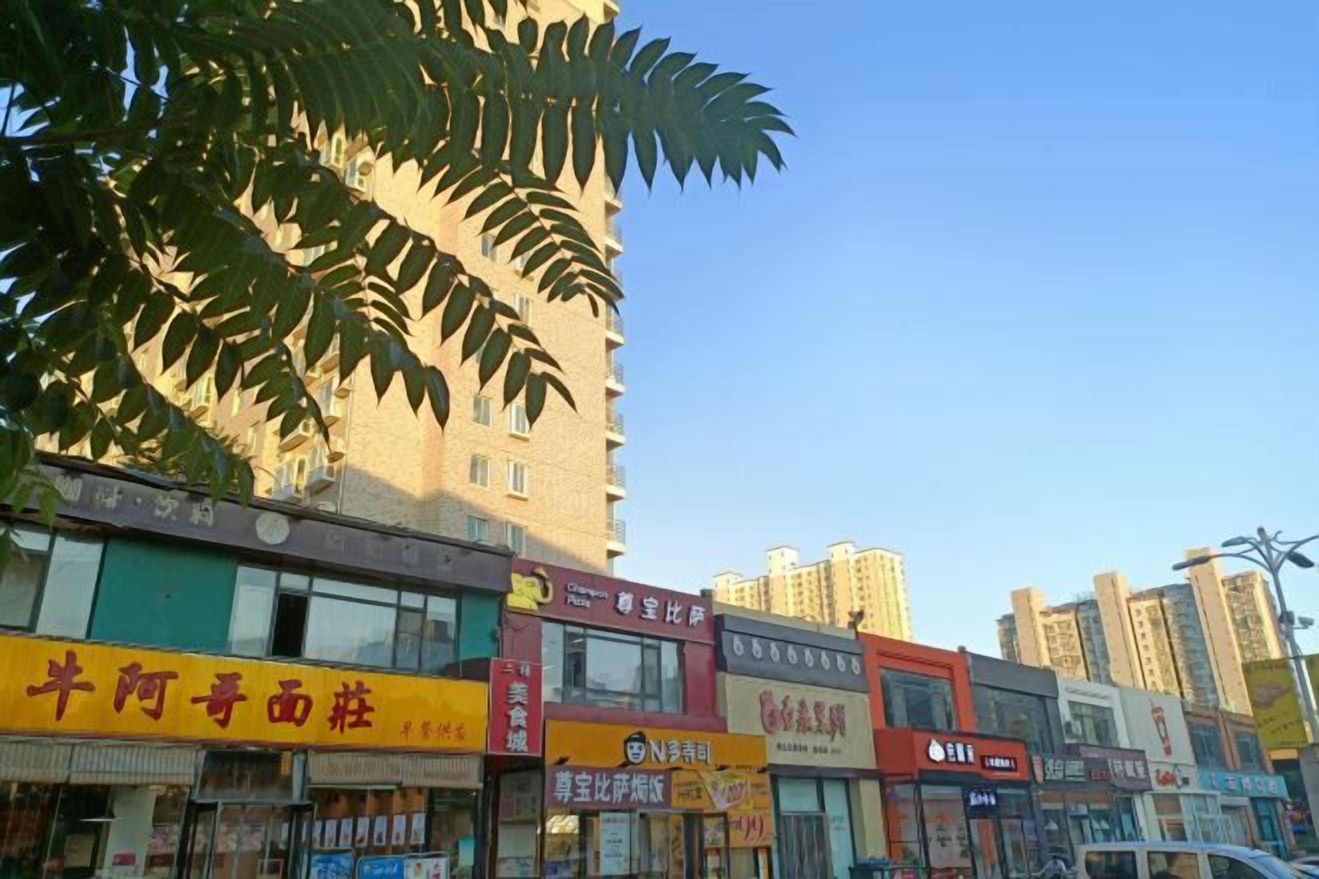 A street view with multiple commercial buildings, including a pharmacy and a restaurant.