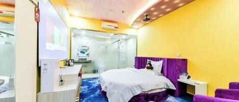 A hotel room with a bed, a desk, a chair, and a ceiling with a floral pattern.