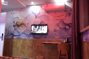 A restaurant interior with a television mounted on the wall, a wooden counter, and a trash bin. - Jinqilin Hostel (Shanghai Waigaoqiao) (Shanghai)