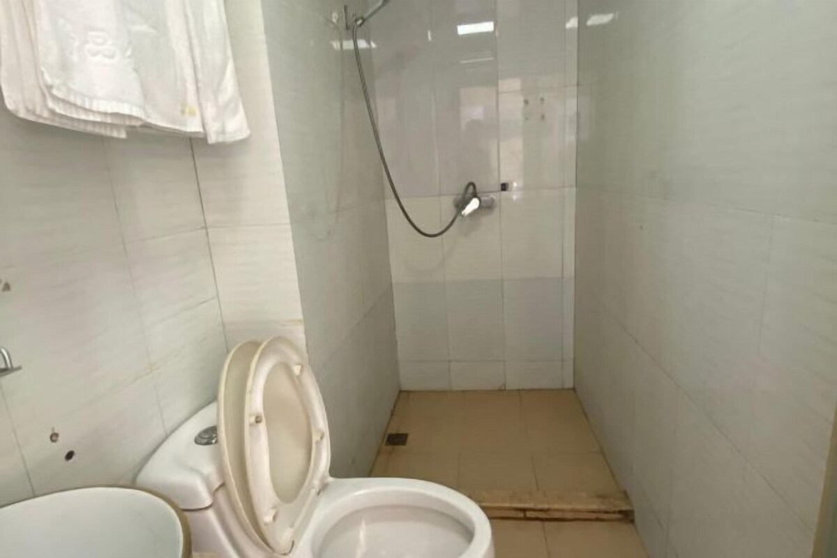 A bathroom with a toilet, a shower, and a sink.