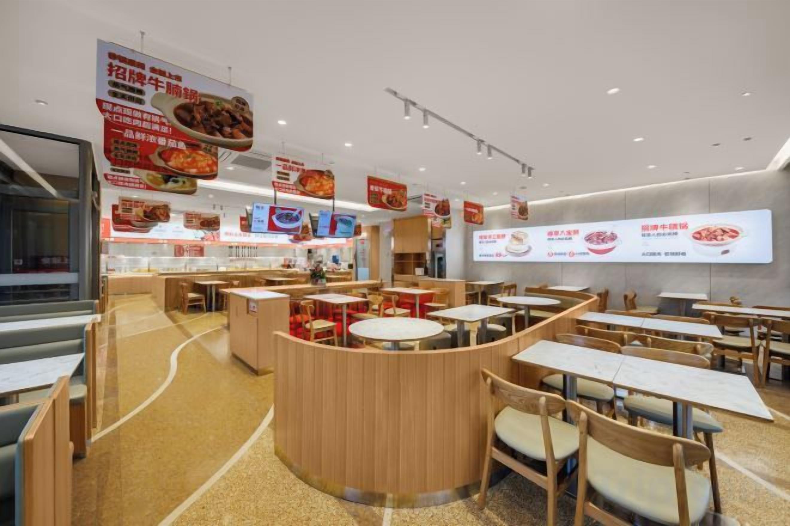 A restaurant interior with round tables, booths, and a counter area.