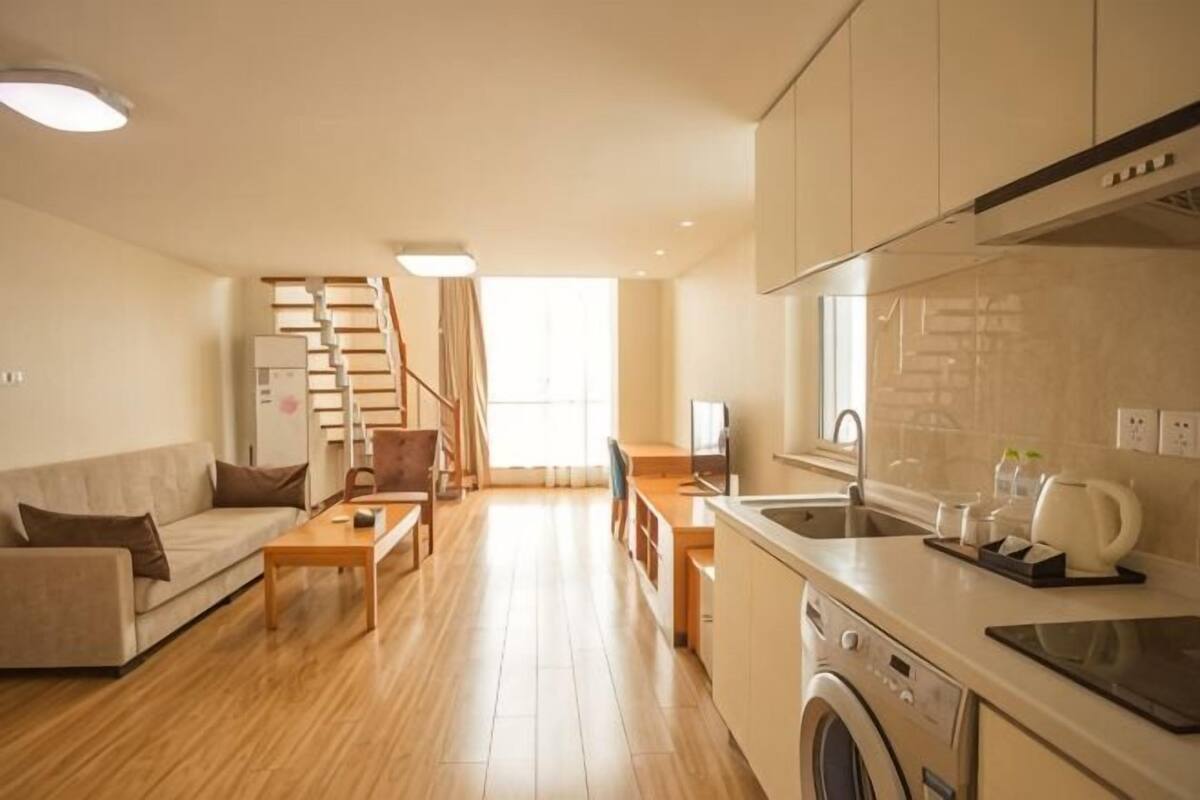A modern apartment with a kitchen, dining area, and living room.