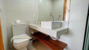 Un bagno con il water, un lavandino e uno specchio.