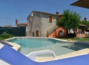A stone building with a pool, outdoor seating, and a clear sky. - Authentic Istrian Rooms for Unforgettable Stays - Triple Room (Vodnjan)