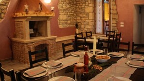 A dining area with a stone wall, a brick fireplace, and wooden chairs. - Authentic Istrian Rooms for Unforgettable Stays - Double Room (Vodnjan)