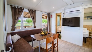 Habitación pequeña con sofá, mesa de comedor y televisor.