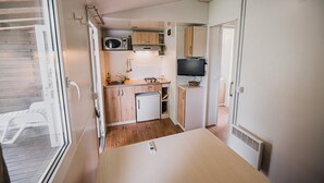 Eine kleine Küchenzeile mit Mikrowelle, Spüle und kleinem Kühlschrank.