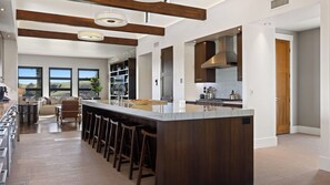 A modern kitchen with a large island, bar stools, and a view of the outdoors. - Wine Country Estate w/ Pool, Hot Tub The Residence at Truss Wines by Avantstay (Paso Robles)
