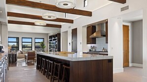 A spacious kitchen with a large island, bar stools, and a view of the outdoors. - Wine Country Estate w/ Pool, Hot Tub The Residence at Truss Wines by Avantstay (Paso Robles)