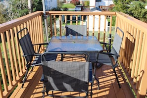 Una terraza de madera con una mesa y sillas.
