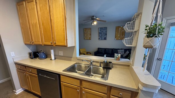 A modern kitchen with wooden cabinets, a dishwasher, and a sink.