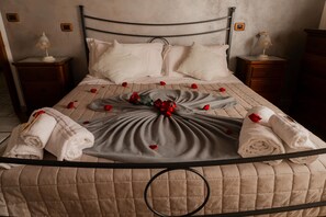 Un lit bien fait, avec une couvre-lit matelassé, des oreillers et une composition décorative de roses et de serviettes.
