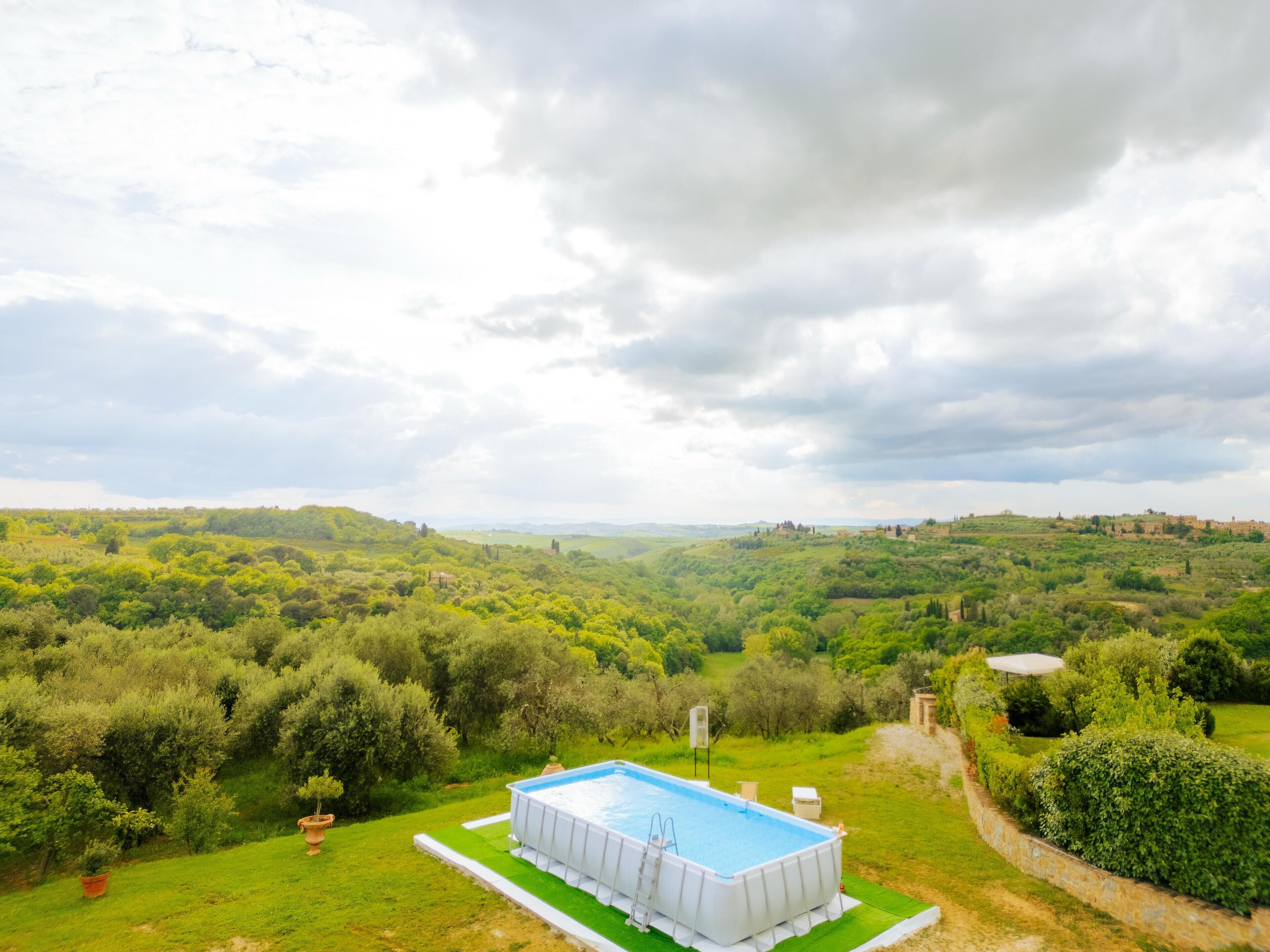 A swimming pool with a view of a lush green landscape and distant hills.