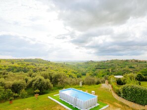 A swimming pool with a view of a lush green landscape and distant hills. - Apartment beautiful sunset farmhouse pascianella (Castelmuzio)