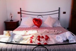 A bed with a heart-shaped balloon, rolled towels, and rose petals. - Apartment beautiful sunset farmhouse pascianella (Castelmuzio)