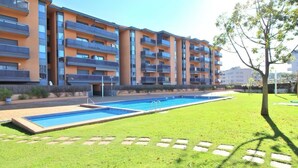 Un immeuble d’appartements moderne doté d’une piscine et d’une pelouse bien entretenue.