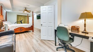 Une chambre d’hôtel équipée d’un lit, d’un bureau, d’une chaise et d’un ventilateur de plafond.