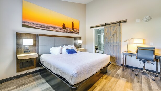 Ein Hotelzimmer mit Bett, Nachttischen, Schreibtisch und Stuhl.