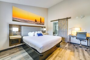 A hotel room with a bed, bedside tables, a desk, and a chair. - Pet-Friendly Studio Near Lighthouse Beach! (Port Huron)