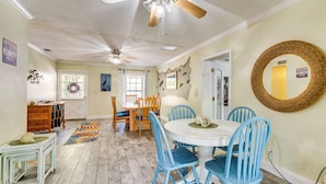 A dining area with a round table and blue chairs, a ceiling fan, and a decorative mirror on the wall. - Boat Slip & Fire Pit: Peaceful Homosassa Home (Homosassa)