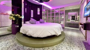 A modern bedroom with a circular bed, purple accents, and a patterned floor. - Shanghai Hua Yu The Tophams Hotel (Shanghai)