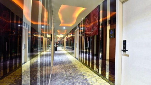 A hotel corridor with a patterned floor, glass doors, and a modern ceiling design. - Shanghai Hua Yu The Tophams Hotel (Shanghai)