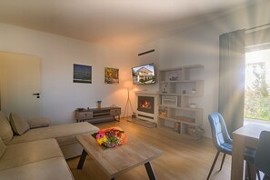 Una Smart TV, una chimenea, un futbolín, libros