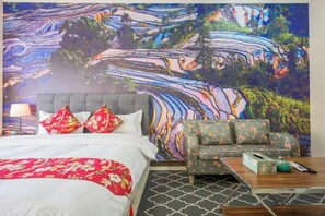 A bedroom with a large bed, a sofa, a coffee table, and a wall mural. - Guangzhou Jingting Humanities Inn (Pazhou Convention and Exhibition Center) (Guangzhou)